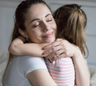 Jeune femme tenant dans ses bras une enfant 