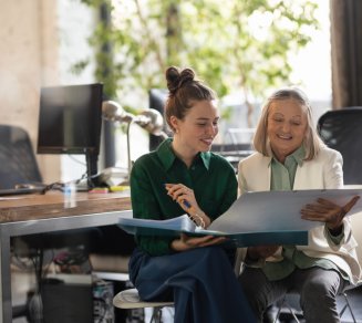 senior en train de travailler en entreprise avec une collaboratrice plus jeune
