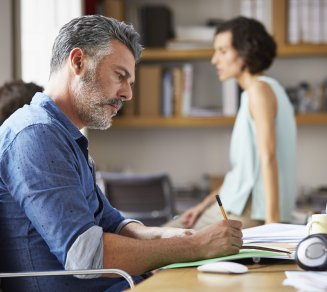 Homme d’affaire concentré sur des documents, illustrant l’impact économique des dépassements d’honoraires médicaux. 