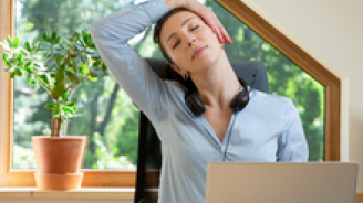 jeune femme qui fait de l’exercice et s’étire devant son ordinateur portable à la maison, en tété travail, pour préserver son capital santé.