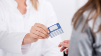 jeune médecin souriante donnant une carte de tiers payant ou carte mutuelle à un patient