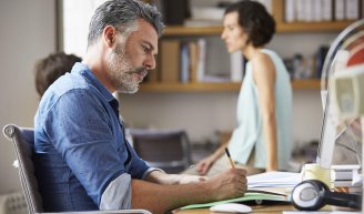 Homme d’affaire concentré sur des documents, illustrant l’impact économique des dépassements d’honoraires médicaux. 